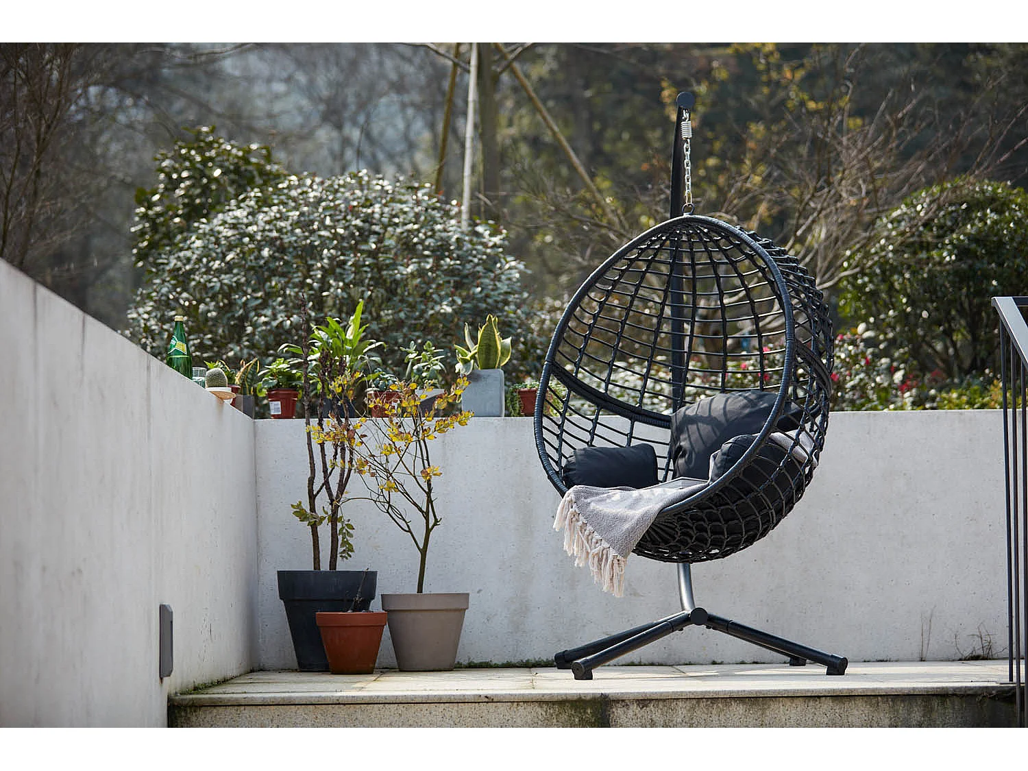 Zwarte hangstoel van gevlochten kunsthars AUROA met stalen frame – Strak design voor binnen en buiten